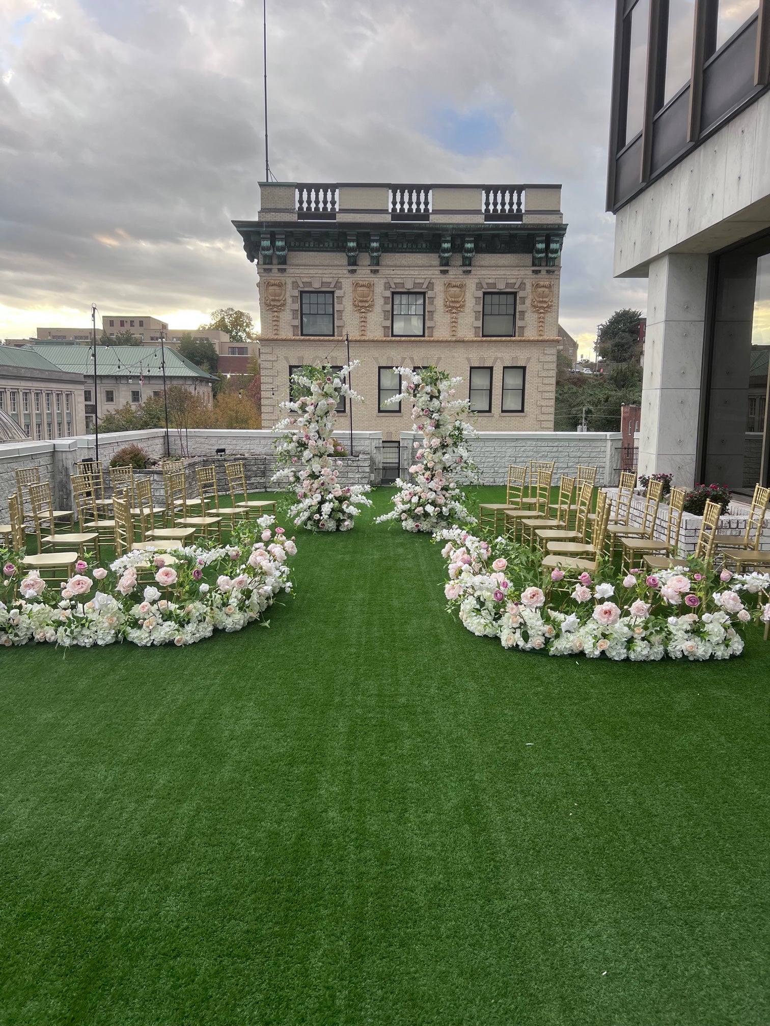 Flower Arch with Aisle flowers. Pillars are made with beautiful soft blush garden roses, ballet pink dahlias, soft blush peonies, white garden roses, white playa blanca roses, blush ranunculus, mauve roses, ivory hydrangeas, blush sweet pea's, white ranunculus, and white delphinium, with touches of eucalyptus, peach juliet garden roses, and clematis. 