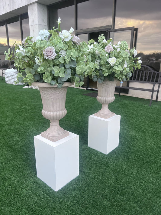 These floral urns are made with eucalyptus, taupe roses, white roses, white ranunculus, and white lisanthus. They are light and airy.