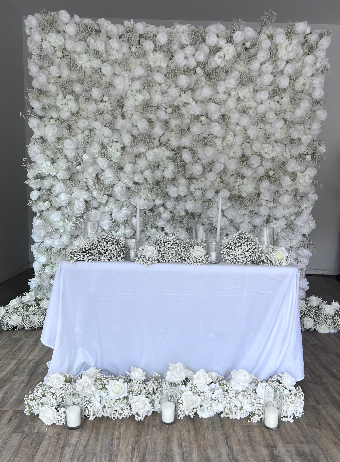 This Flower Wall Backdrop is made from beautiful white roses and babys breath. Featuring other white rose and babys breath wedding table centerpieces/ decor. 