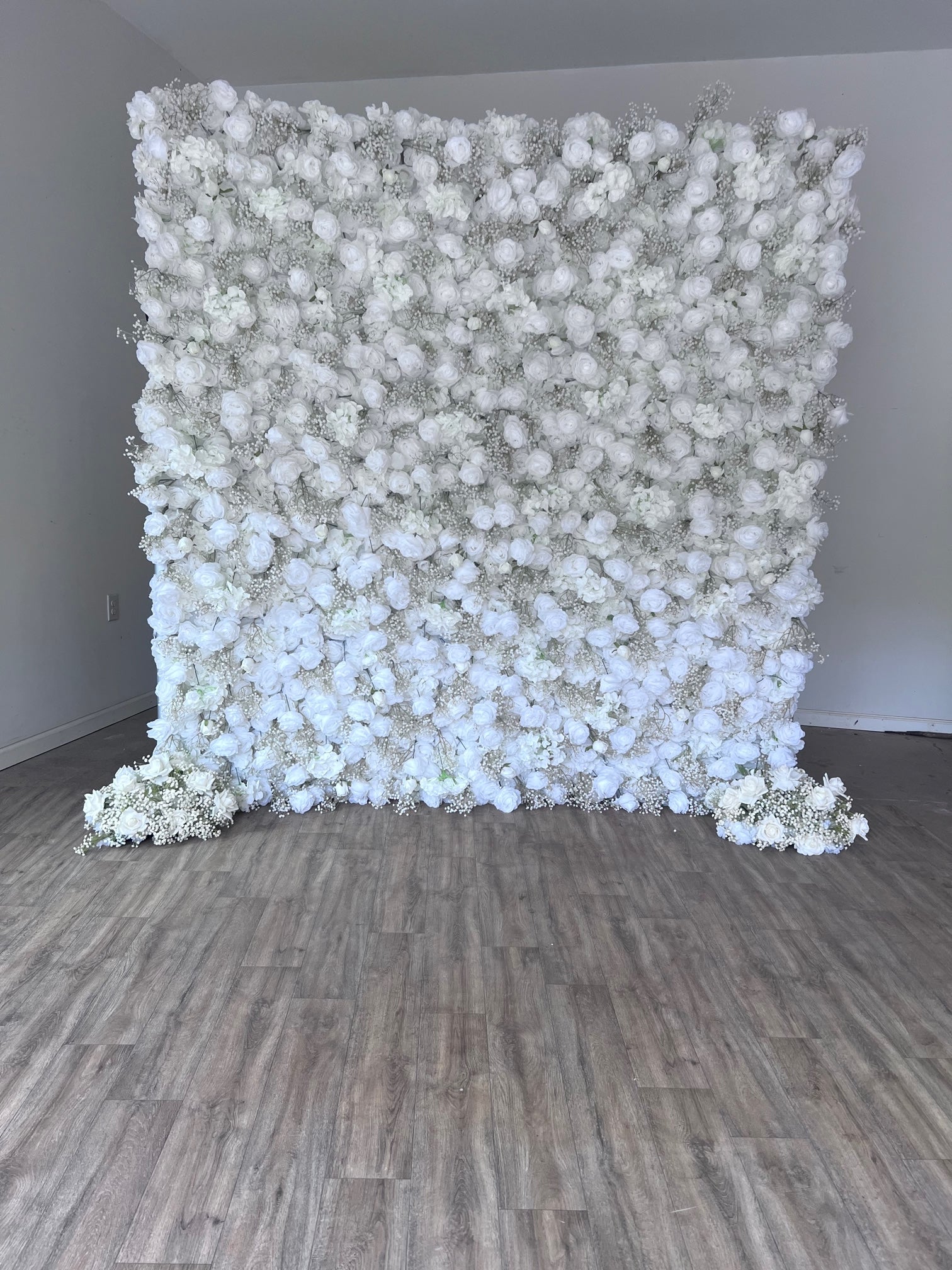 The Aveline Flower Wall Backdrop is made from beautiful white roses and babys breath.