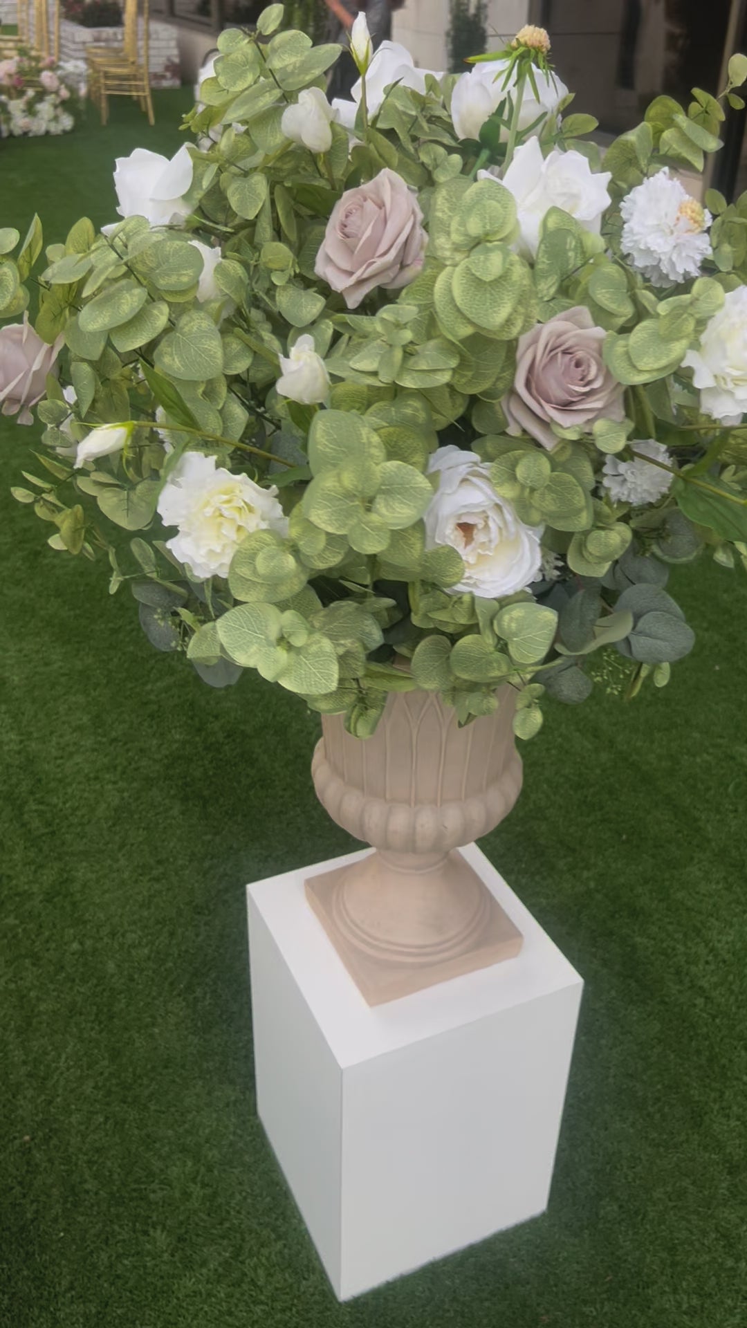 These floral urns are made with eucalyptus, taupe roses, white roses, white ranunculus, and white lisanthus. They are light and airy.